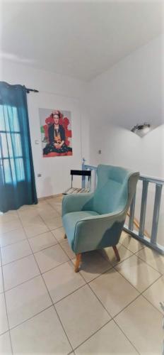 a green chair sitting on a tiled floor in a room at Syros Dreamy Maisonette 2 minutes from sandy beach in Liaropá