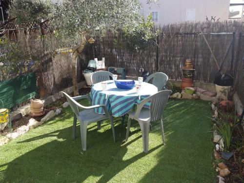 a table and chairs in a backyard with a fence at Apartment Le Nausicaa by Interhome in Bandol