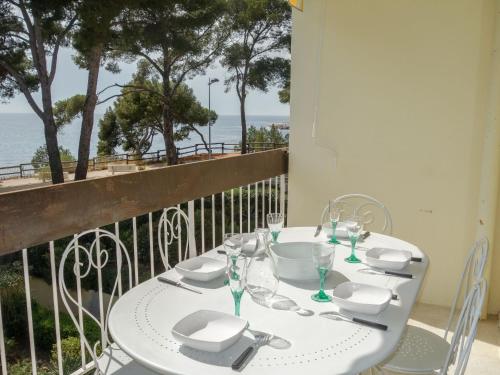 - une table blanche avec des verres à vin sur le balcon dans l'établissement Apartment La Calanque d'Or by Interhome, à Bandol