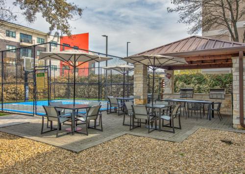 a patio with tables and chairs next to a pool at Staybridge Suites Plano - Richardson Area by IHG in Plano