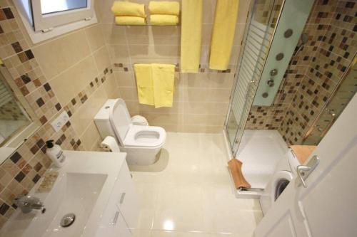 a bathroom with a toilet and a sink and towels at Studio in beachfront complex in El Duque area, Costa Adeje in Adeje