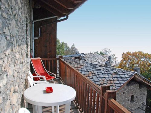 a wooden balcony with a table and chairs on it at Apartment Grand Sarriod-5 by Interhome in Saint Nicolas