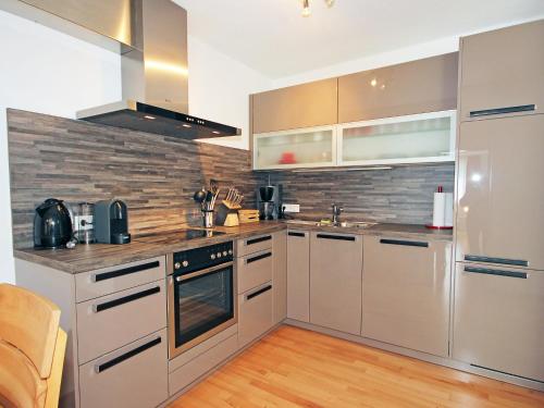 a kitchen with stainless steel appliances and wooden floors at Apartment Living House Vandans by Interhome in Vandans