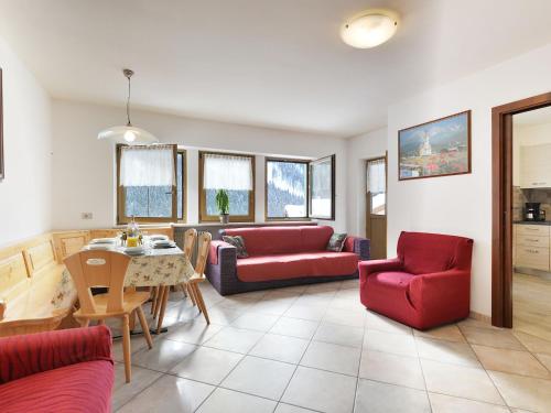 uma sala de estar com sofás vermelhos e uma mesa em Apartment Bernard-2 by Interhome em Campestrin