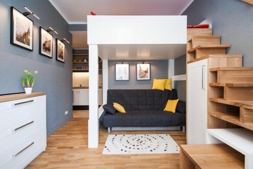 a small living room with a couch and a staircase at Zulu Apartments Old Town in Krakow