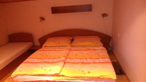 a bed in a small room with a bedspread on it at Mária Kičáková TATRY MKS in Štrba
