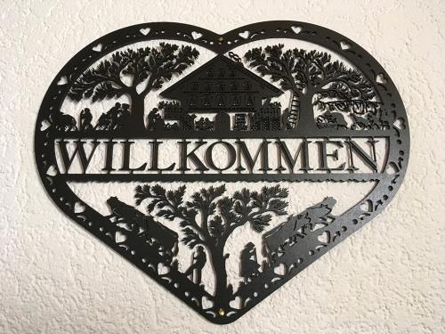 a heart shaped sign on a wall with the word willushima at Pension Chalet Charme in Siebnen