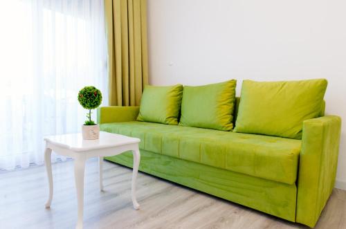a green couch in a living room with a table at Apartments Hoxha in Ulcinj