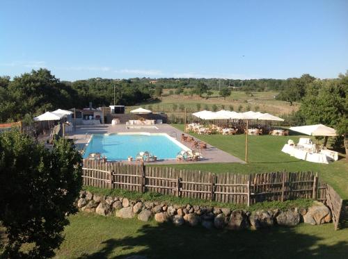 蒙泰菲亞斯科內的住宿－卡潘納山莊農場假日酒店，一个带围栏的院子内的游泳池