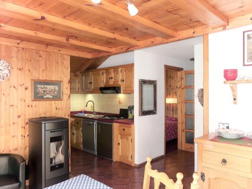 una cucina con armadi in legno e stufa nera di Apartment Coup d'Coeur by Interhome a Valtournenche