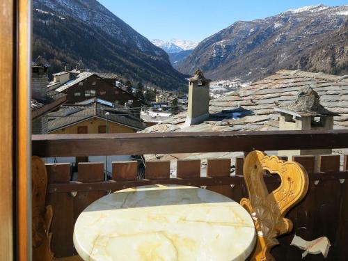 a table and chairs on a balcony with mountains at Apartment Plen Solei by Interhome in Valtournenche