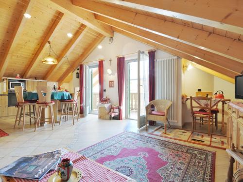 ein großes Wohnzimmer mit Holzdecken und eine Küche in der Unterkunft Apartment Maura-1 by Interhome in Pozza di Fassa