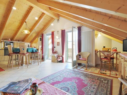 a large living room with wooden ceilings and a kitchen at Apartment Maura-1 by Interhome in Pozza di Fassa