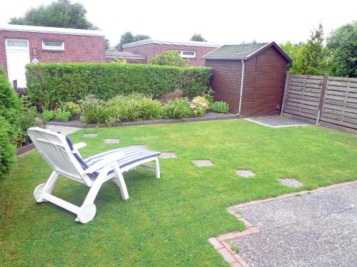 a white chair sitting on the grass in a yard at Holiday Home Seefalke by Interhome in Norddeich