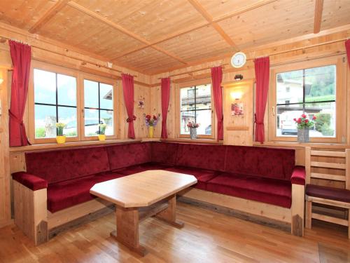 a red couch in a room with windows at Holiday Home Schwendau-2 by Interhome in Hippach