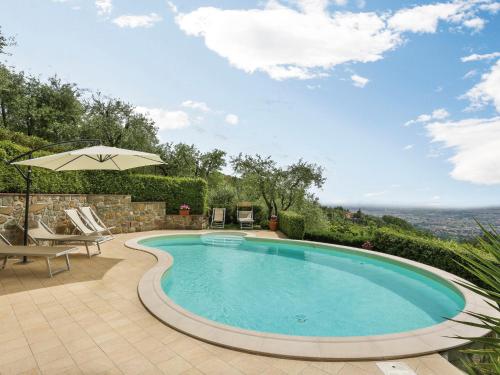 a swimming pool with an umbrella on a patio at Holiday Home Villa I Cipressi by Interhome in Nievole