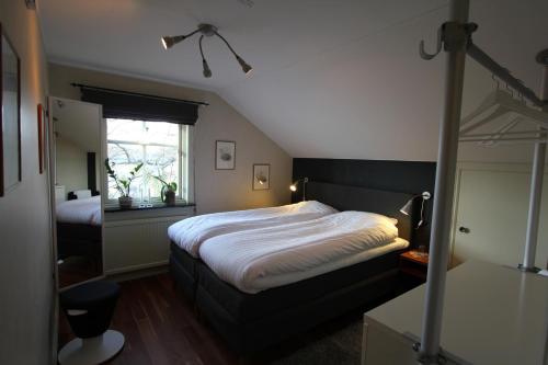 Un dormitorio con una cama grande y una ventana en At Home Bed & Breakfast, en Gotemburgo