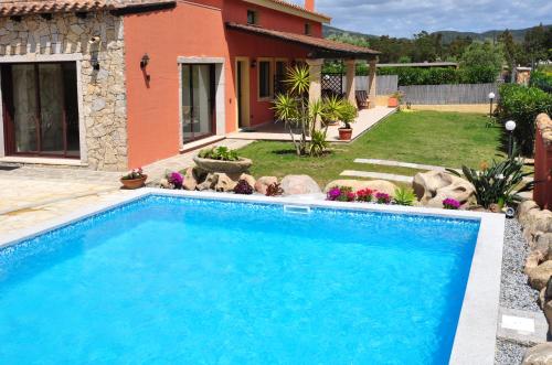 a swimming pool in the yard of a house at B&B I Graniti Sardi in Villasimius