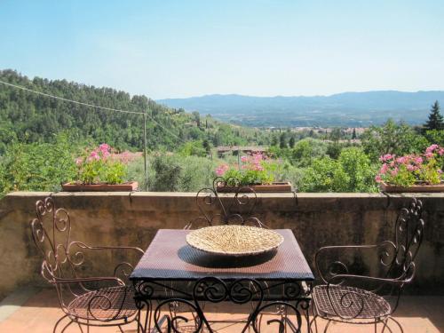 una mesa y sillas en un balcón con flores en Holiday Home Borgo La Cella-1 by Interhome, en Pian di Scò