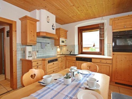 - une cuisine avec une table et de la vaisselle dans l'établissement Apartment Höpperger by Interhome, à Flaurling