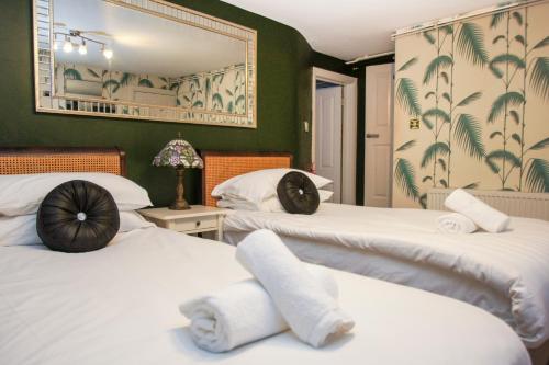 duas camas num quarto com paredes verdes em Chocolate Box - Central- by Brighton Holiday Lets em Brighton & Hove