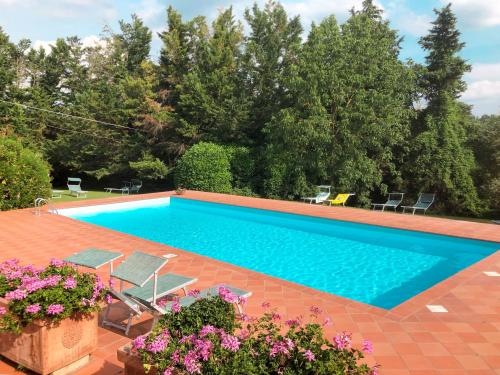 a swimming pool with chairs and flowers in a yard at Holiday Home Bardeggiano - Caterina 7 by Interhome in Belvedere