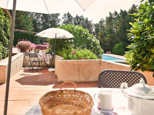 einen Tisch mit einem Sonnenschirm auf einer Terrasse in der Unterkunft Holiday Home Bardeggiano - Caterina 7 by Interhome in Belvedere