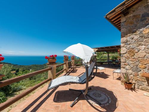 d'une terrasse avec un parasol, des chaises et l'océan. dans l'établissement Villa Ricali by Interhome, à Porto Santo Stefano