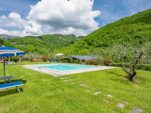 Il MolinaccioにあるHoliday Home La Fornace-1 by Interhomeのテーブルと傘が備わる庭のスイミングプール