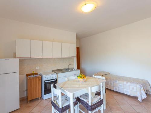 eine kleine Küche mit einem Tisch und einem Bett in der Unterkunft Apartment Villa Tavaglione-1 by Interhome in Peschici