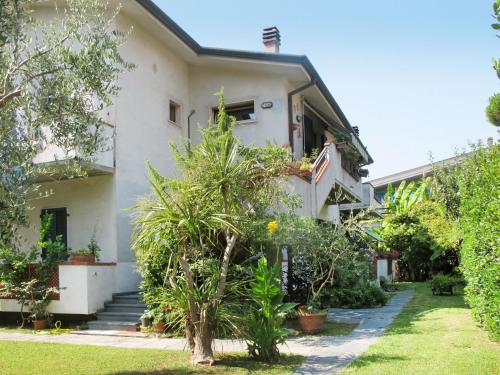 una casa bianca con alberi e piante nel cortile di Apartment Ilaria by Interhome a Marina di Massa