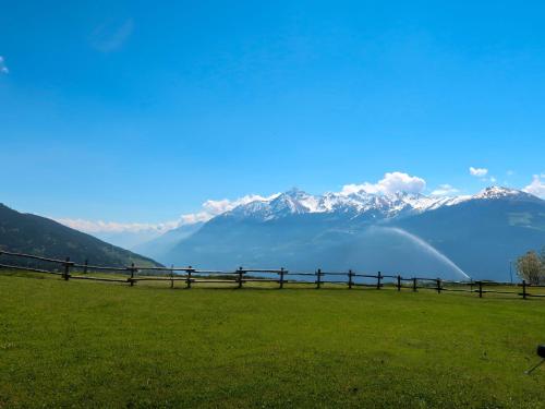 a fence in a field with mountains in the background at Apartment Vetan by Interhome in Saint Nicolas
