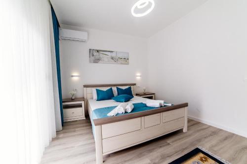 a bedroom with a bed with blue pillows at Apartments Hoxha in Ulcinj