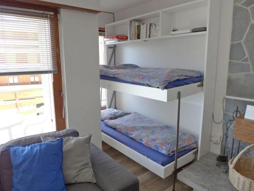 two bunk beds in a room with a couch at Apartment Rond-Point Apt- 17 by Interhome in Crans-Montana