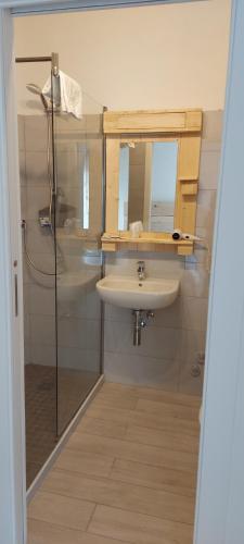 een badkamer met een wastafel en een spiegel bij Albergo Vittoria in Ledro