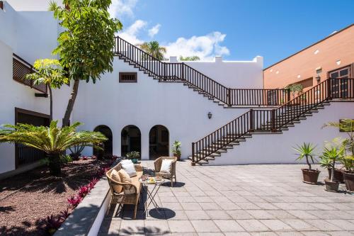 a patio with chairs and stairs in a building at Hotel Hacienda del Conde Meliá Collection Golf & Spa - Adults Only in Buenavista del Norte