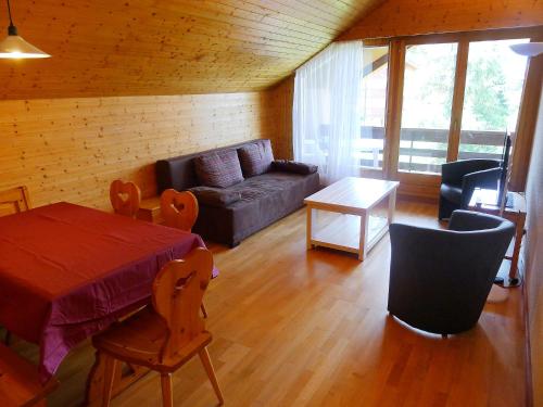 uma sala de estar com um sofá e uma mesa em Apartment Grenat 35 by Interhome em Villars-sur-Ollon