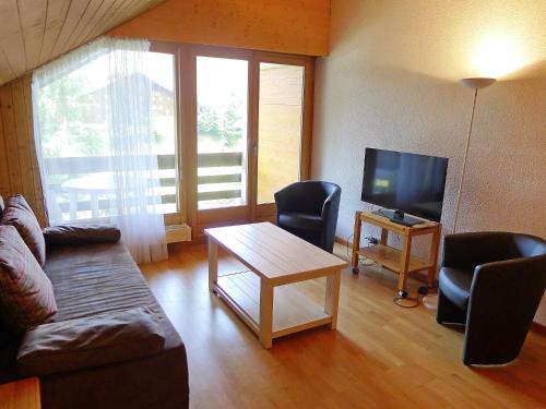 - un salon avec un canapé, une table et une télévision dans l'établissement Apartment Grenat 35 by Interhome, à Villars-sur-Ollon