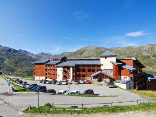 a large building with cars parked in a parking lot at Apartment Nécou-1 by Interhome in Les Menuires