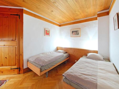 a bedroom with two beds and a wooden ceiling at Holiday Home Les Clèves by Interhome in Nendaz
