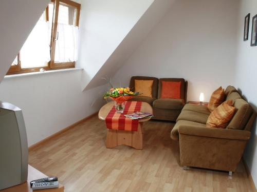 ein Wohnzimmer mit einem Sofa und einem Tisch in der Unterkunft Apartment Dieboldshof by Interhome in Neuried