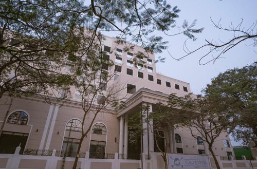 a white building with trees in front of it at Hotel Polo Towers Agartala in Agartala