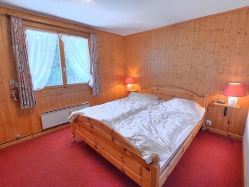 Chalet Clarine by Interhome في أنزير: غرفة نوم بسرير خشبي ونافذة