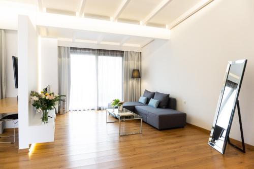 a living room with a couch and a mirror at City Loft Hotel in Patra