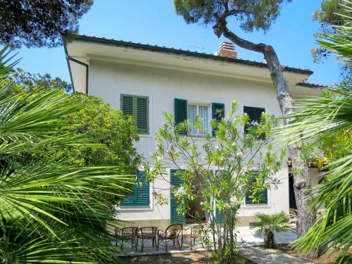 Case FortullinoにあるHoliday Home Nella by Interhomeの緑の艶戸と木々のある白い家