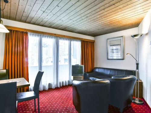 グリンデルワルトにあるApartment Chalet Abendrot-12 by Interhomeのソファとテレビが備わるホテルルーム