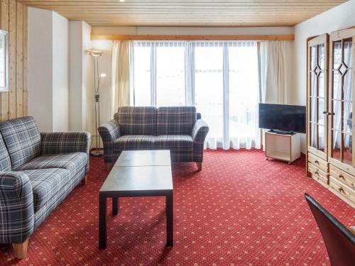 - un salon avec des canapés, une table et une télévision dans l'établissement Apartment Chalet Abendrot-27 by Interhome, à Grindelwald