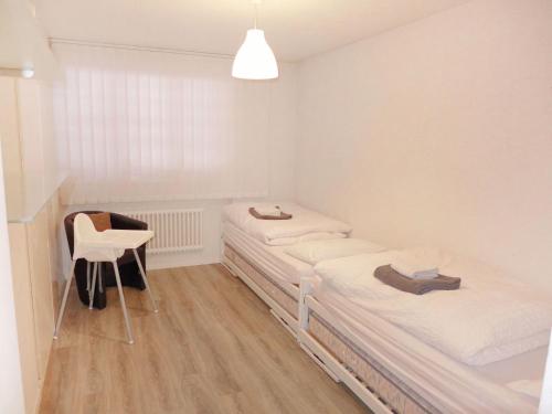 a room with two beds and a chair in it at Apartment Barzettes-Vacances 454 - Entrée N- 14 by Interhome in Vermala