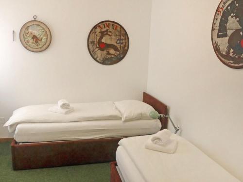 a bedroom with two beds and two clocks on the wall at Apartment Chesa Sonnalpine B 46 by Interhome in St. Moritz