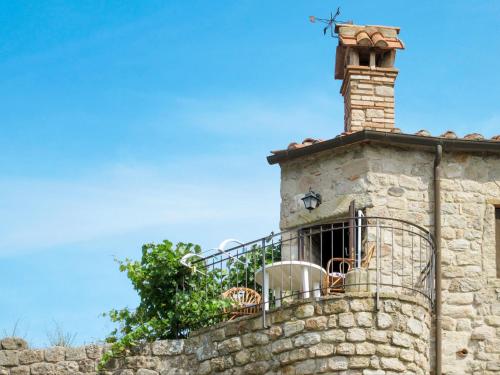 kamienny budynek z kominkiem i balkonem w obiekcie Apartment Torretta - Borgo la Civitella by Interhome w mieście Roccastrada